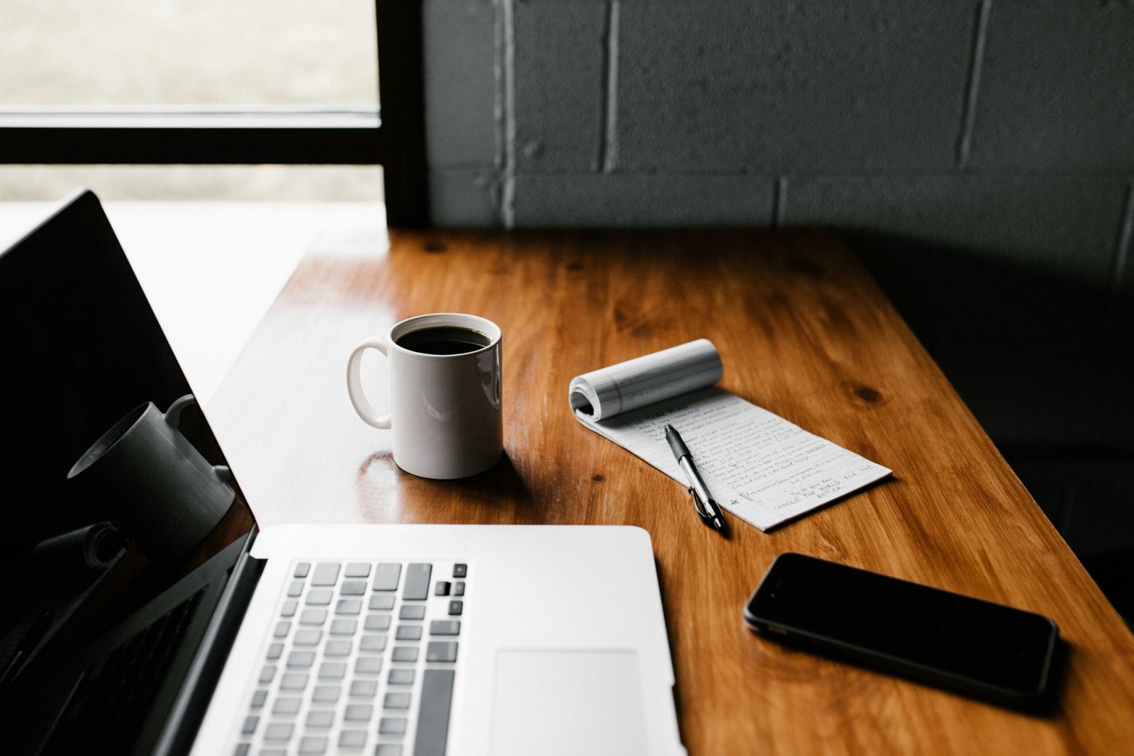 Real estate investor workspace with laptop and notebook for deal tracking